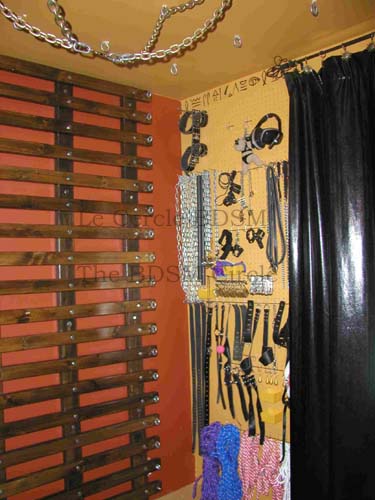 photo du mur gauche en entrant, sur lequelle il y a le rack de bondage et vue partielle du mur extrieur