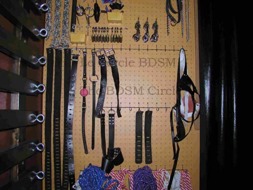 picture of the middle part of the outside wall cover by the pegboard with the BDSM toy on it